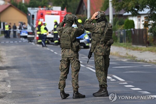 드론이 추락한 폴란드의 한 마을에서 소방관들이 잔해를 수습하는 것을 군인들이 지켜보고 있다. @연합뉴스