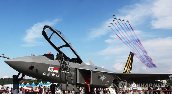 지난 19일 경기도 성남시 서울공항에서 열린 '서울 국제항공우주 및 방위산업 전시회(ADEX)'에서 공군 특수비행팀 블랙이글스가 전시 중인 KF-21 위로 비행하고 있다. @연합뉴스 